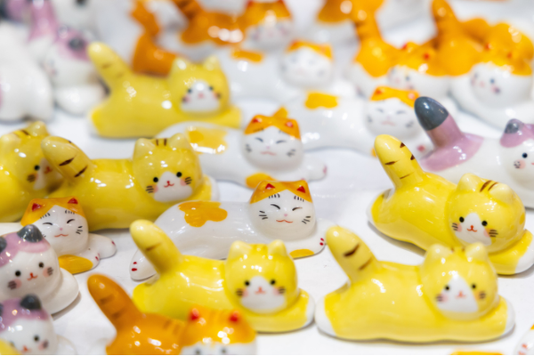 Array of ceramic cat chopstick rests in yellow and white