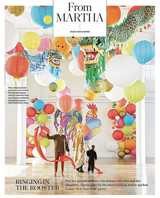Martha Stewart with large dragon decoration, lanterns, and grandchild