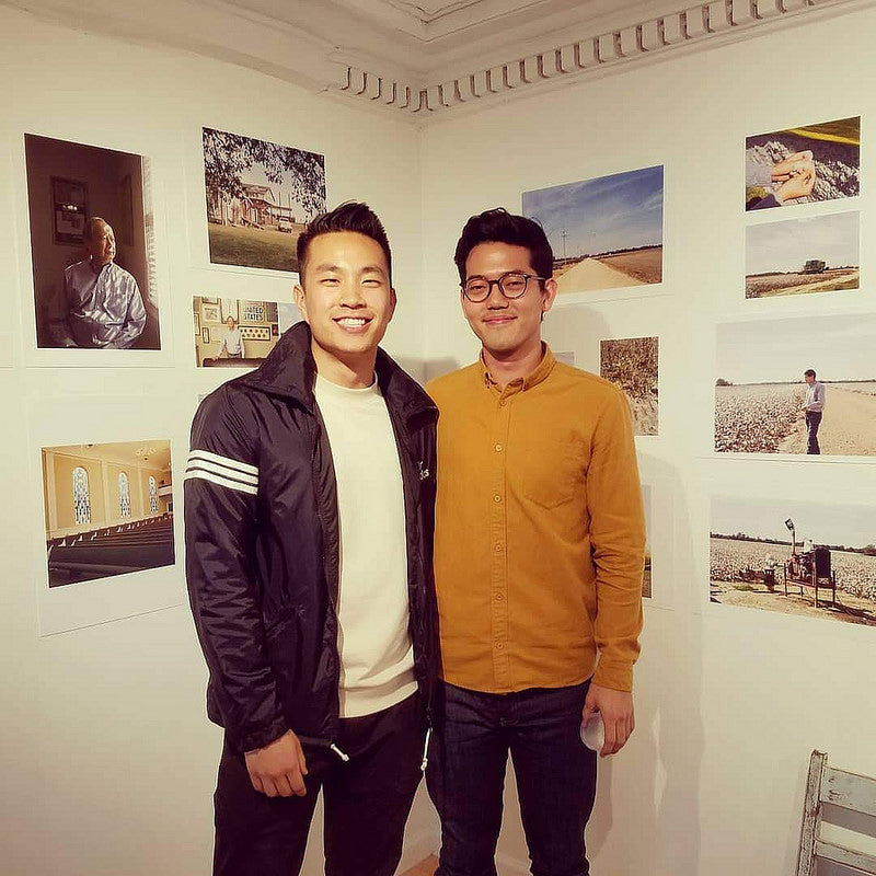Photographers Andrew Kung and Emanuel Hahn in front of their photos in the Pearl River Mart gallery in Tribeca