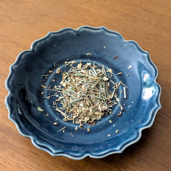 Blue ceramic bowl with herbal tea on a wooden surface