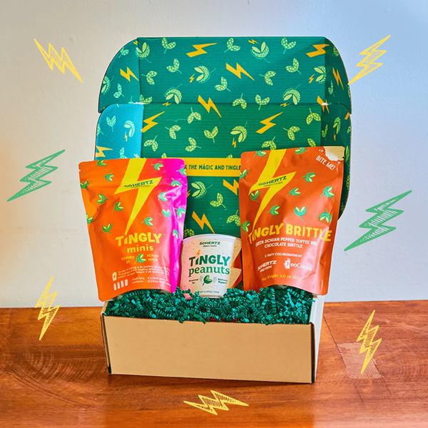 Box of Tingly snacks with a green patterned lid on a wooden surface.