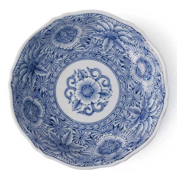 A round ceramic plate with a blue and white floral pattern, featuring a central floral medallion and detailed botanical designs around the rim.
