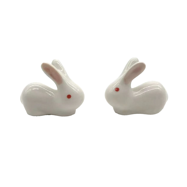 Two white ceramic rabbit chopstick rests on a white background
