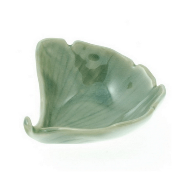 Green ceramic leaf-shaped dish on a white background