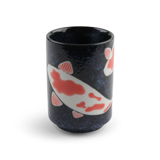 A black ceramic cup features colorful koi fish with red and white patterns, creating a serene, artistic design. The background has a subtle speckled texture.
