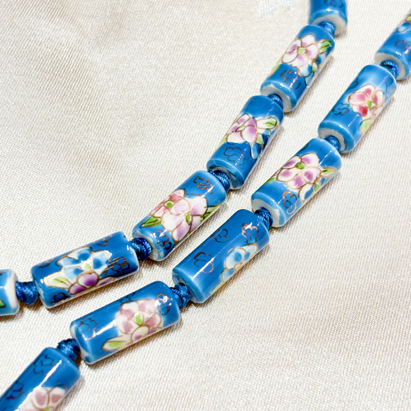 Close up of tube-shaped cloisonne design necklace - azure