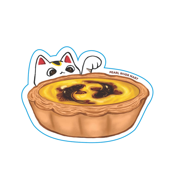 A die-cut sticker featuring a cartoon maneki-neko cat peeking behind a golden tart with dark fish illustrations on top, outlined in blue, with the text 'PEARL RIVER MART' on a white background.