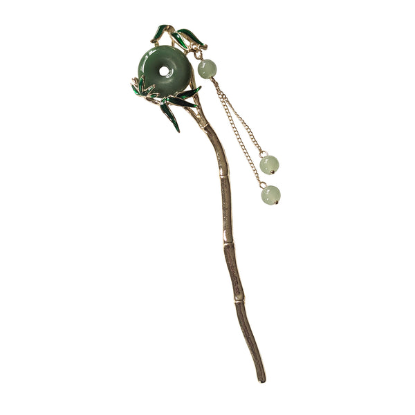 Decorative hair stick with green stone and chain on a white background