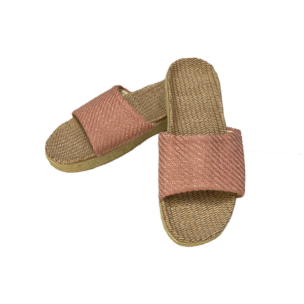 Pair of woven sandals with pink straps on a white background
