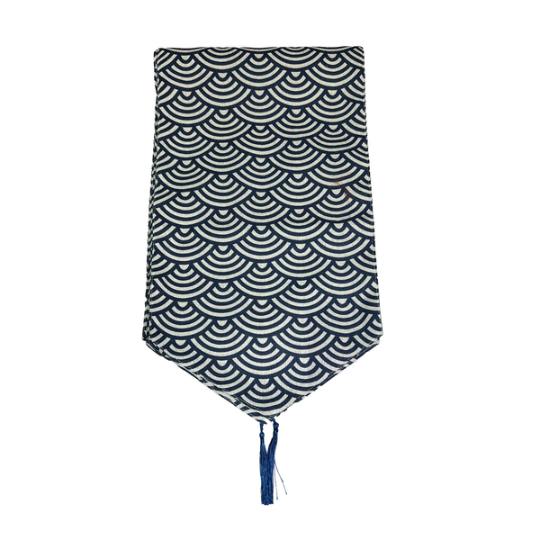 Blue and white wave pattern table runner with a blue tassel on a white background