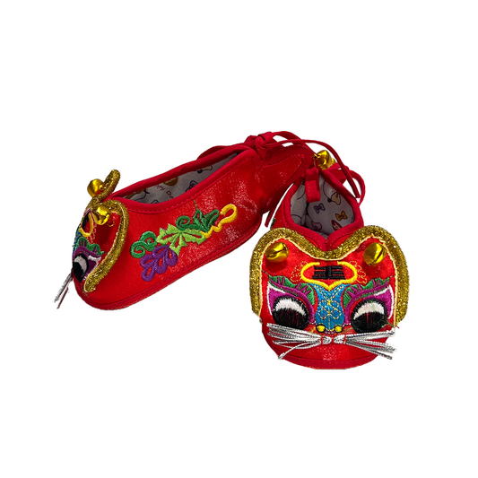 Red embroidered shoes with colorful designs on a white background