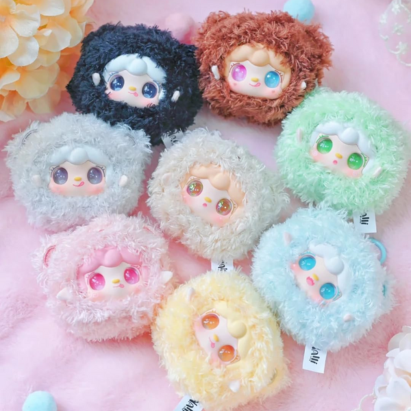 Set of colorful plush toys with cartoon faces on a pink background