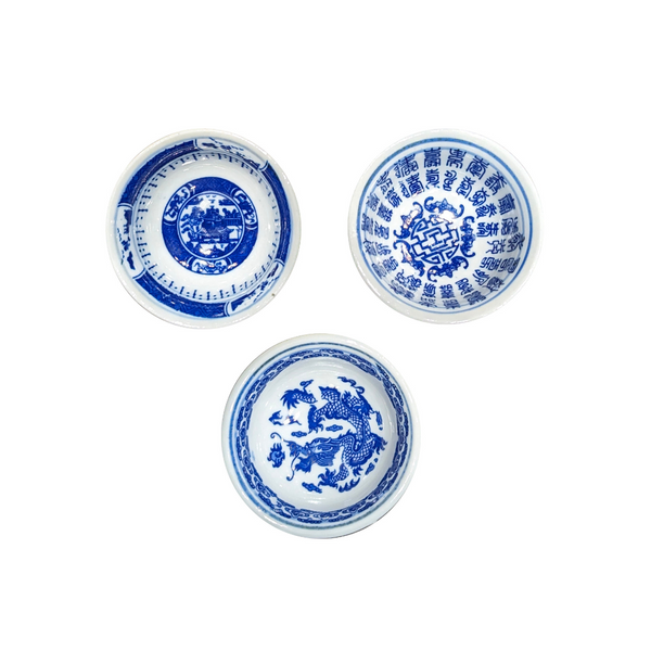 Three blue and white ceramic sauce dishes with intricate designs on a white background