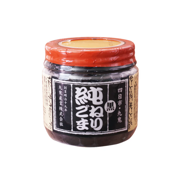 Jar of black sesame paste with a red lid on a white background