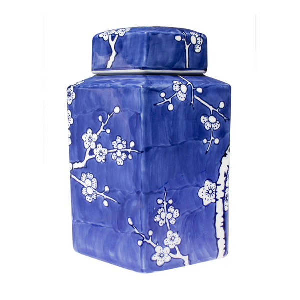 Blue ceramic jar with white floral patterns on a white background