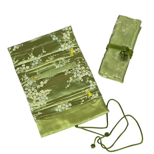Green brocade jewelry roll with white blossoms