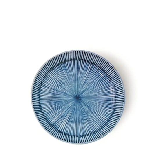 A round ceramic plate with a blue and white radial striped pattern, photographed from directly above on a white background.