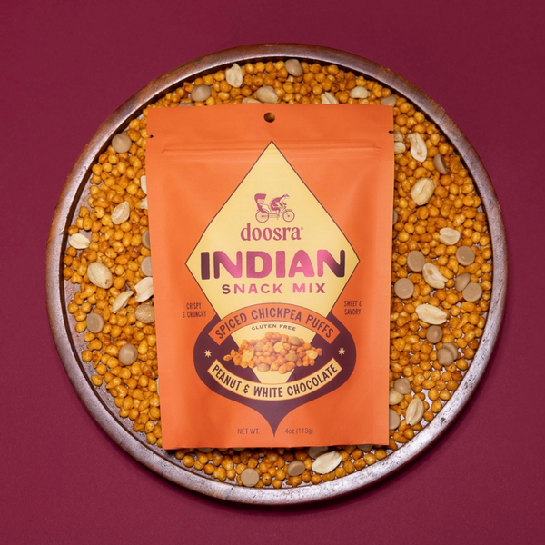 doosra Indian snack mix package on a bed of chickpeas and peanuts with a purple background