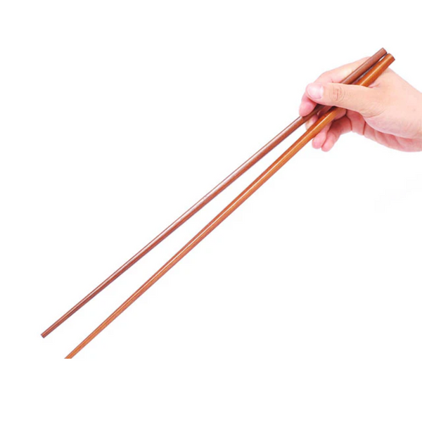 Wooden chopsticks held by a hand on a white background