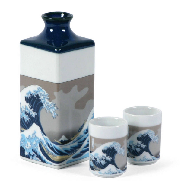 Ceramic sake bottle and two cups with wave design on a white background
