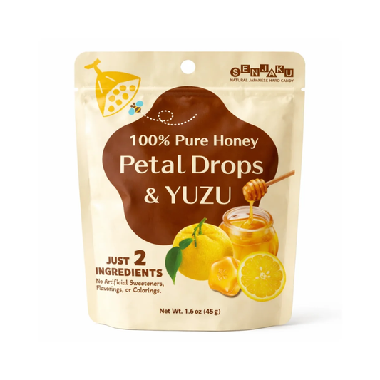 A stand-up pouch of Cenmaru 100% Pure Honey Petal Drops & Yuzu flavor, featuring a cream-colored background with a large brown central label, yellow illustrations of honeycomb and fruit, and a honey jar graphic.