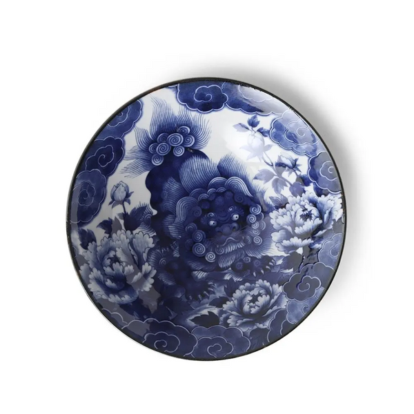 Ceramic bowl with blue floral and fu lion design on a white background