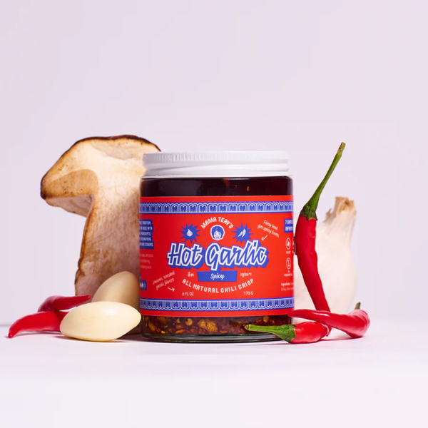 Jar of 'Hot Garlic' with garlic, chili peppers, and a mushroom on a white background