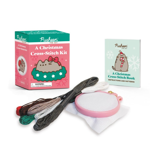 Pusheen Christmas cross-stitch kit with packaging, thread, and needle on a white background