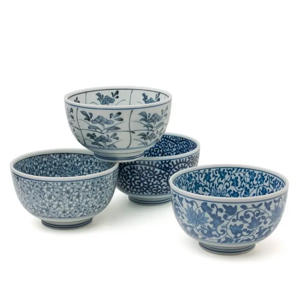 Set of four blue and white floral-patterned ceramic bowls on a white background