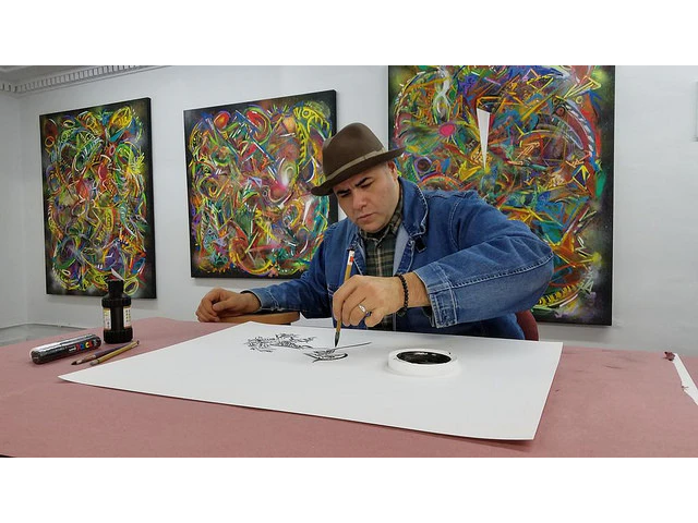 Artist Chris Mendoza painting in front of his work in the Pearl River Mart gallery in Tribeca