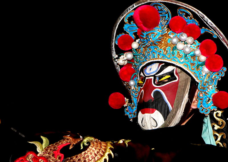 Bianlian or face changing Chinese opera performer in makeup and decorative hat