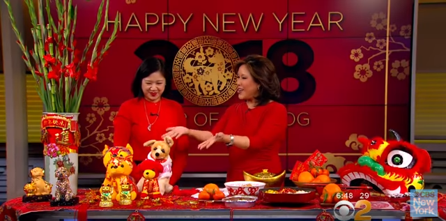 Joanne Kwong speaking Cindy Hsu on CBS morning show in front of Lunar New Year display