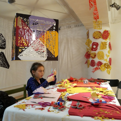 Little girl making papercut crafts at art event in Pearl River Mart