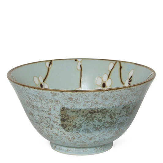 A ceramic bowl with a textured, speckled light blue-green glaze, decorated with delicate white cherry blossoms on a branch pattern inside the rim, set against a plain white background.
