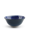 A ceramic bowl with a deep cobalt blue exterior and a lighter blue, white, and gray marbled pattern on the interior, set against a plain white background.