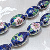 Close up of dark blue porcelain beads with cloisonne and lotus design