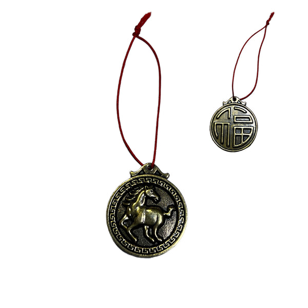 Decorative pendant with horse design on a red string against a white background