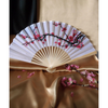 Lovely white fan with delicate black branch of pink blossoms