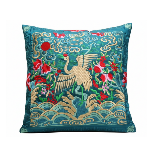 Decorative pillow with embroidered design of a crane and flowers on a blue background