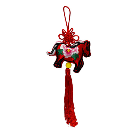 Decorative hanging charm with a red tassel on a white background