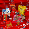 Assorted Chinese New Year treats and decorations on a red background with floral patterns.