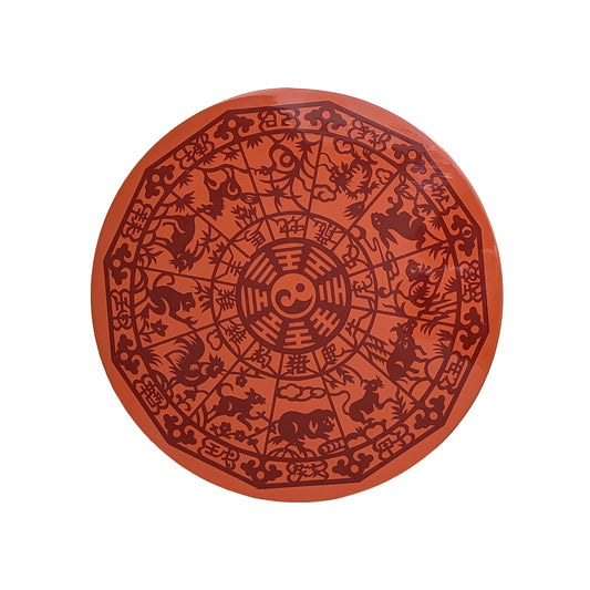 Round red object with intricate black designs on a white background