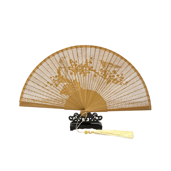 Light brown wooden fan with bird on branch design on dark wood stand on white background