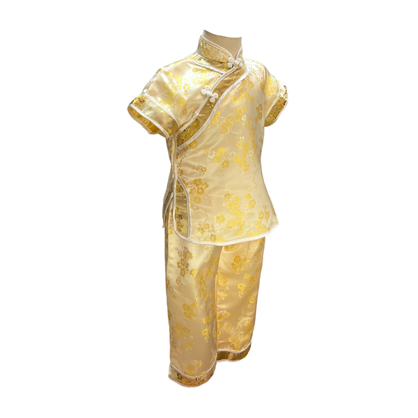 Traditional kids outfit in gold with yellow blossoms on mannequin