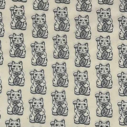 Repeating black-and-white maneki-neko cats with raised paws and coins form a cheerful, vintage-style pattern on a cream background.