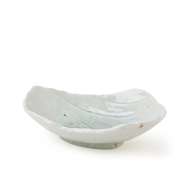 A small, shallow ceramic dish with a leaf-like organic shape, featuring a glossy off-white glaze with subtle light blue-green undertones and a small footed base, set against a plain white background.