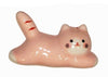 Ceramic cat-shaped object with pink, white, and red colors on a white background.