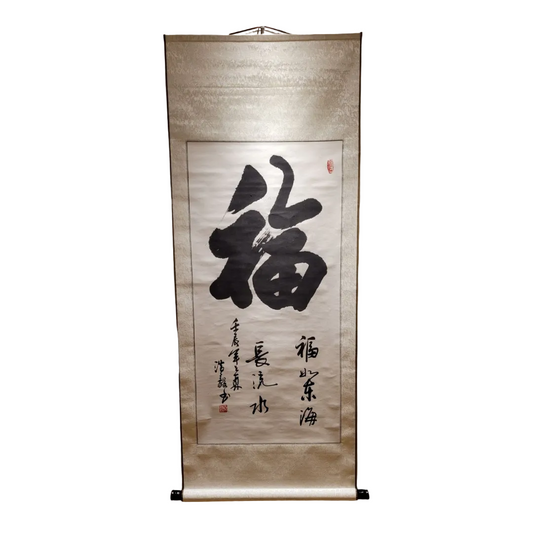 Hanging scroll with calligraphy on a beige wall