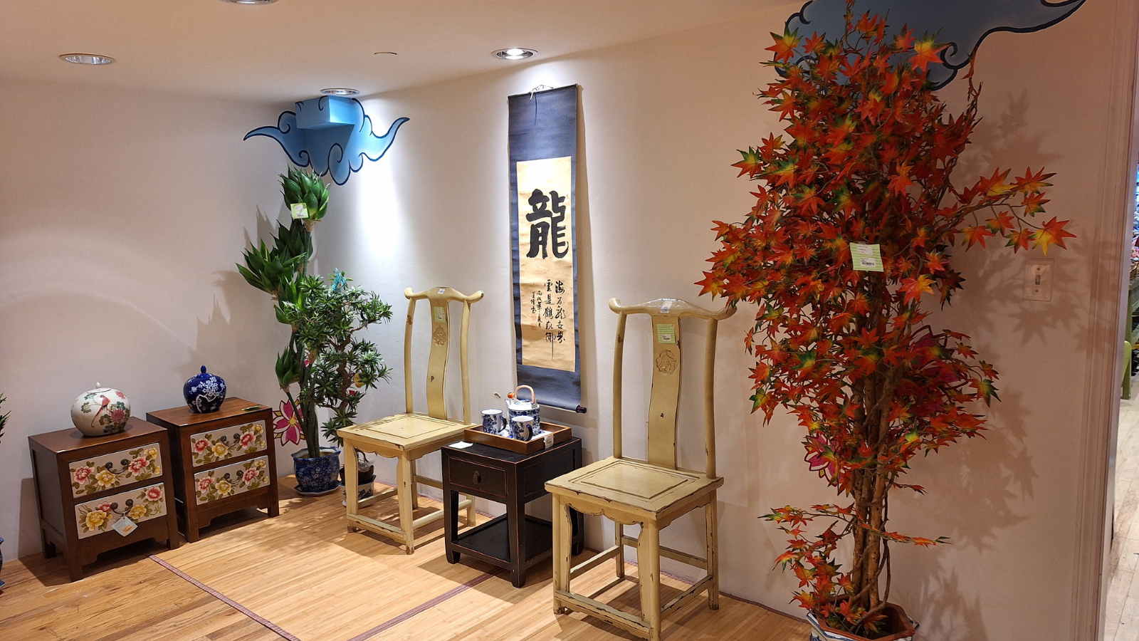 Pearl River Mart gallery with artificial trees, chairs, and scroll 