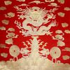 Gold brocade sea dragon on red fabric